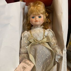 Porcelain doll in original box with stand